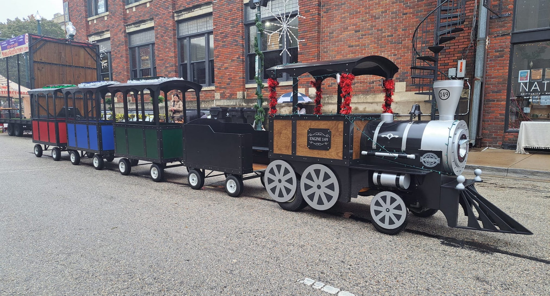 Engine 149 and its passenger cars decorated for a downtown holiday event